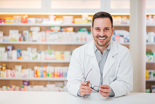 Pharmacien souriant à son comptoir